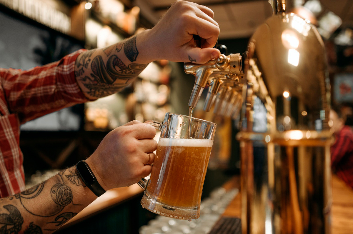 Bartender serving beer in a mug